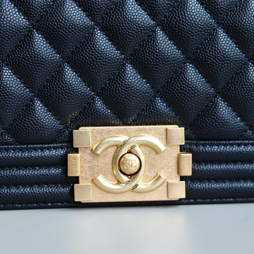 Gold hardware of Chanel logo on black boy chanel handbag