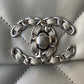 close up of silver chanel logo buckle of light grey chanel 19 handbag silver hardware lamb skin