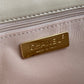 close up of gold hardware logo inside Chanel 19 handbag in beige lamb skin