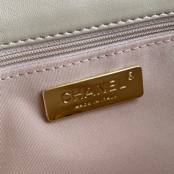 close up of gold hardware logo inside Chanel 19 handbag in beige lamb skin