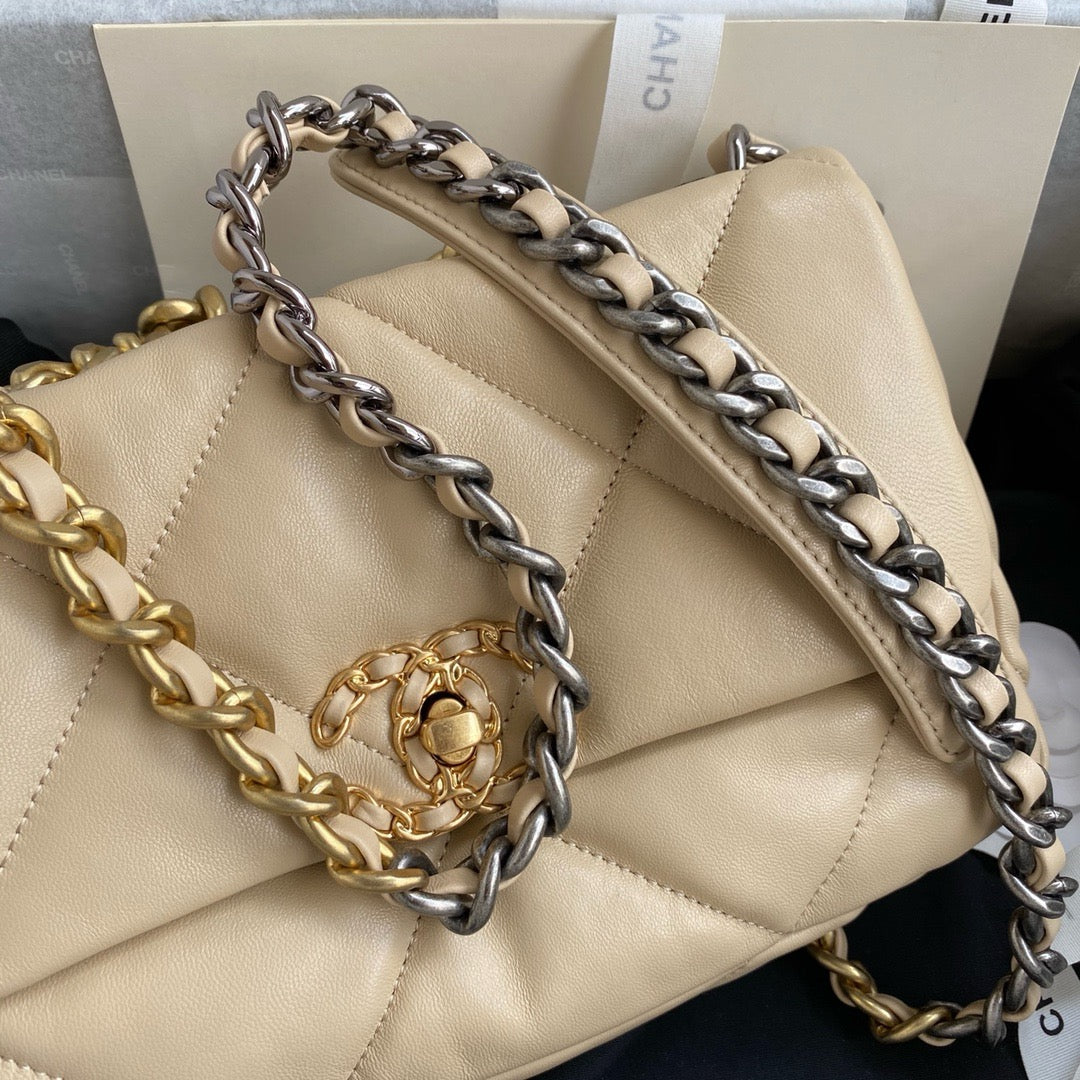 close up of gold and silver tone hardware of Chanel 19 handbag in beige lamb skin