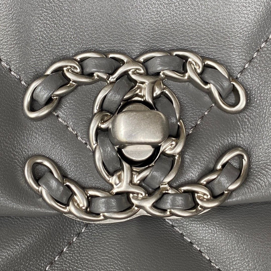 close up of silver chanel logo of Grey chanel 19 handbag in lamb skin silver hardware