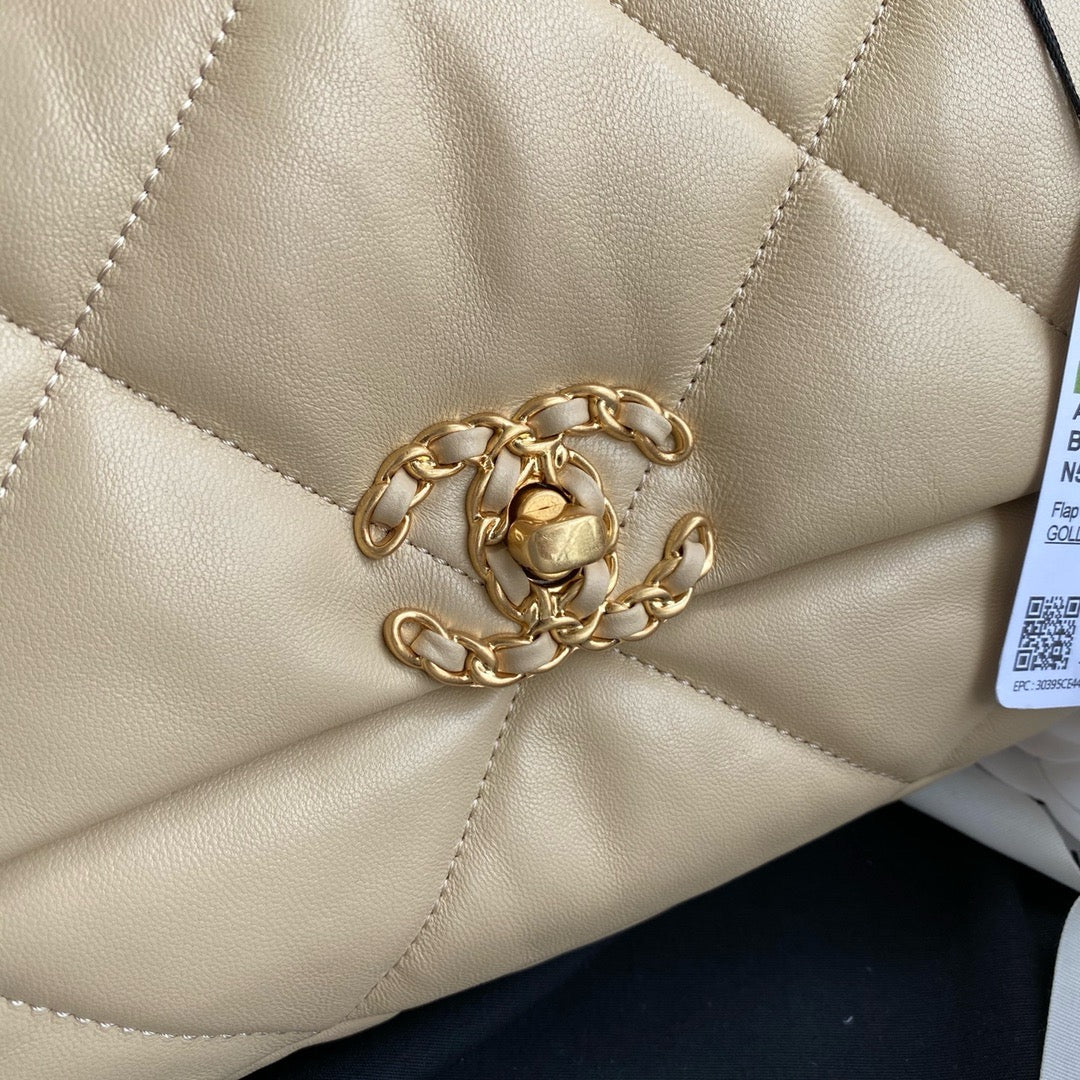 Logo of gold harware buckle of Chanel 19 handbag in beige lamb skin