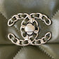 close up of silver chanel logo of khaki chanel 19 handbag lamb skin silver hardware