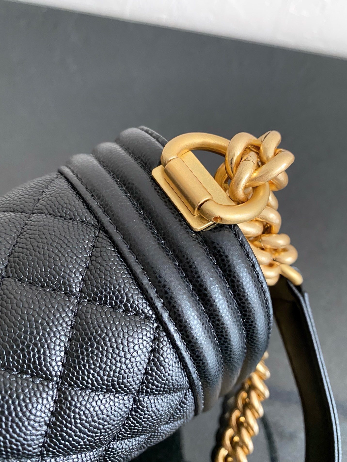 Close up of black boy chanel bag and gold hardware