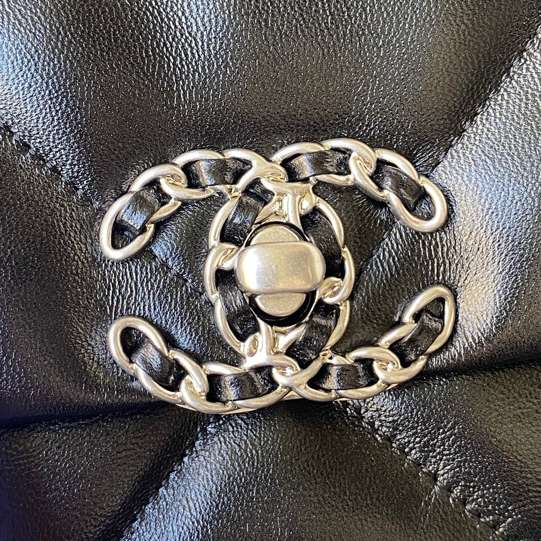 close up of silver logo buckle of chanel 19 handbag in black lamb skin
