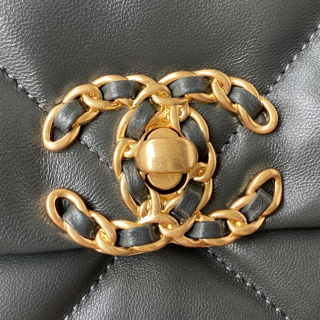 close up of gold chanel logo of Grey chanel 19 handbag in lamb skin gold hardware