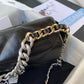 close up of silver and gold hardware chain of chanel 19 handbag in black lamb skin